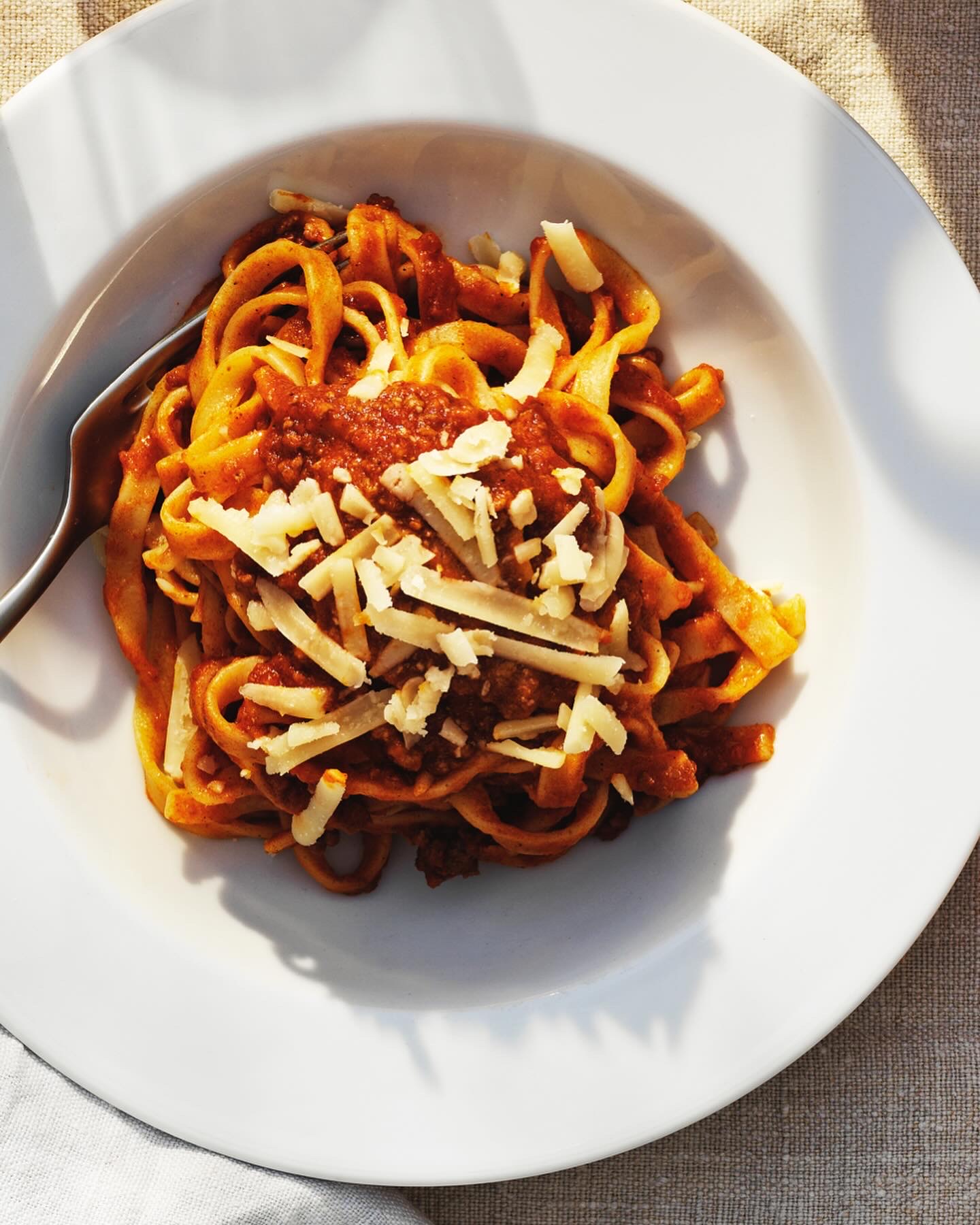 Tallrik med tagliatelle i mustig köttfärssås och riven ost