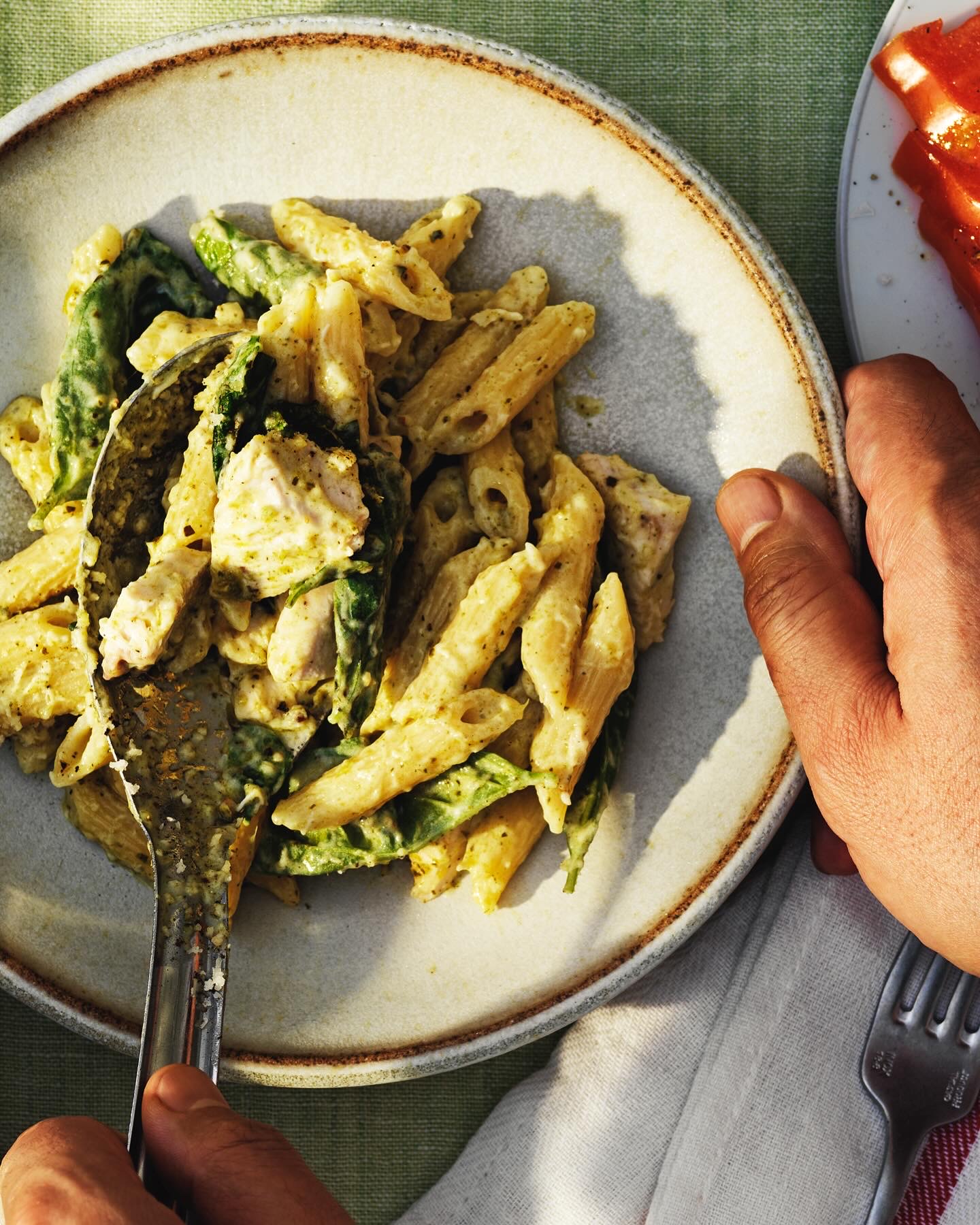 Penne med kyckling, pesto och spenat på tallrik